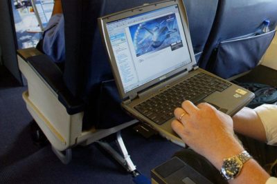 a person using a laptop on an airplane