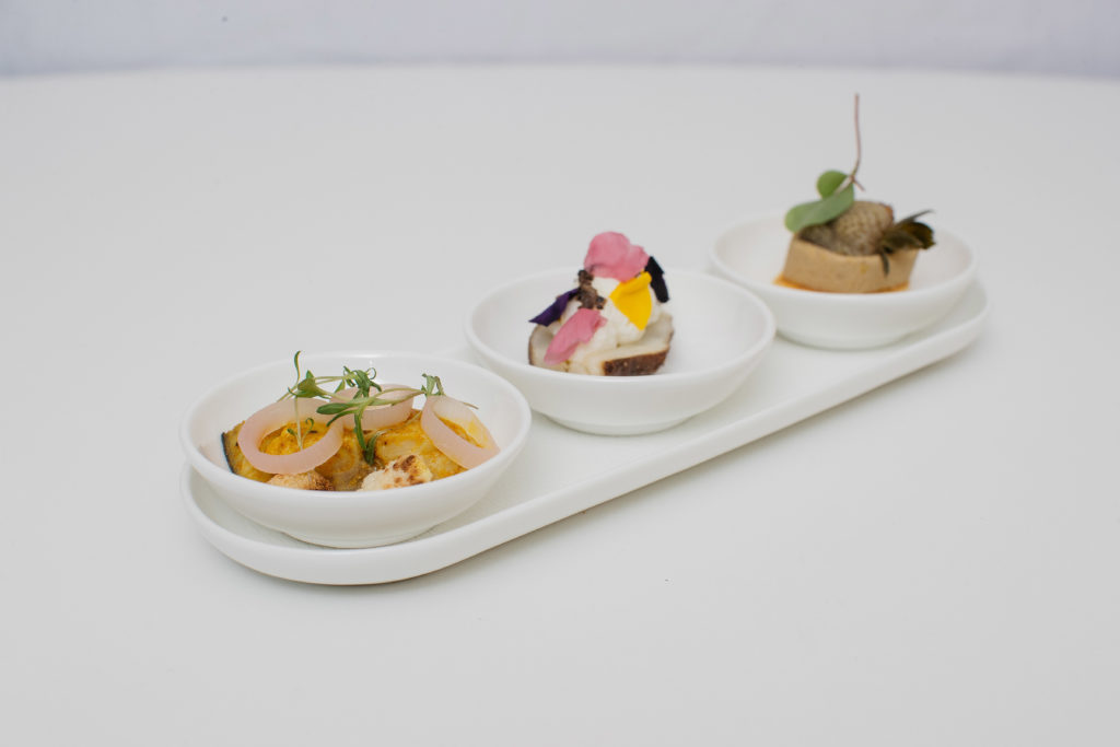 a row of small white bowls with food on them