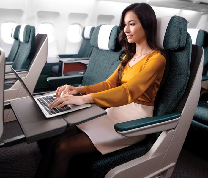 a woman sitting in an airplane using a laptop