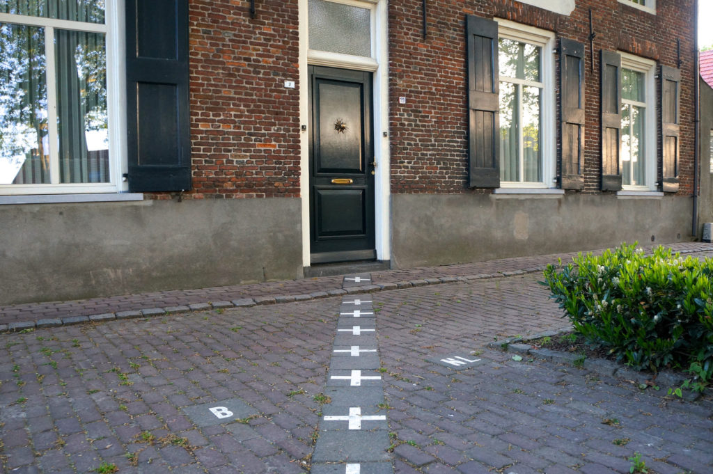 a brick building with a black door and white markings