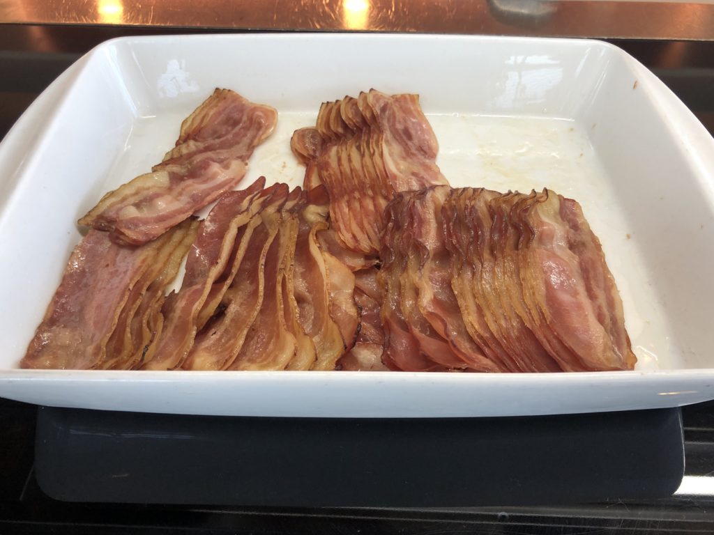 a white rectangular dish with slices of bacon