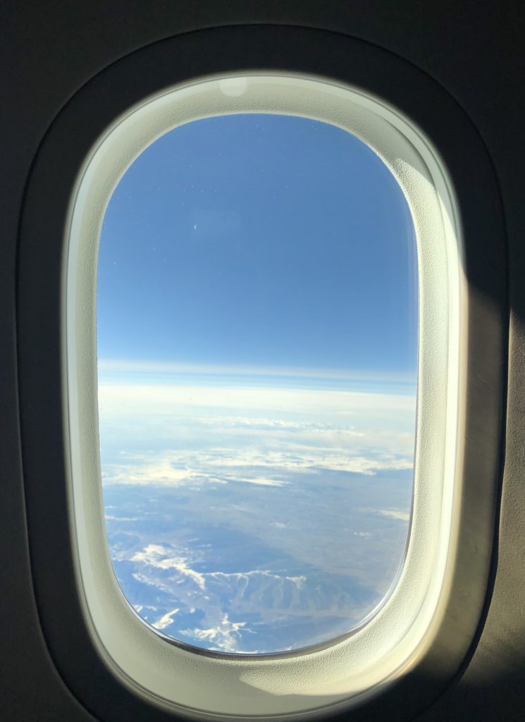 an airplane window with a view of the earth from the window