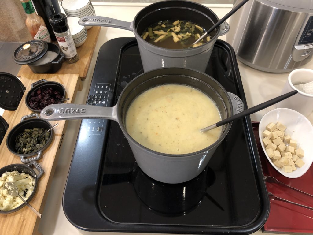 two pots of soup on a stove