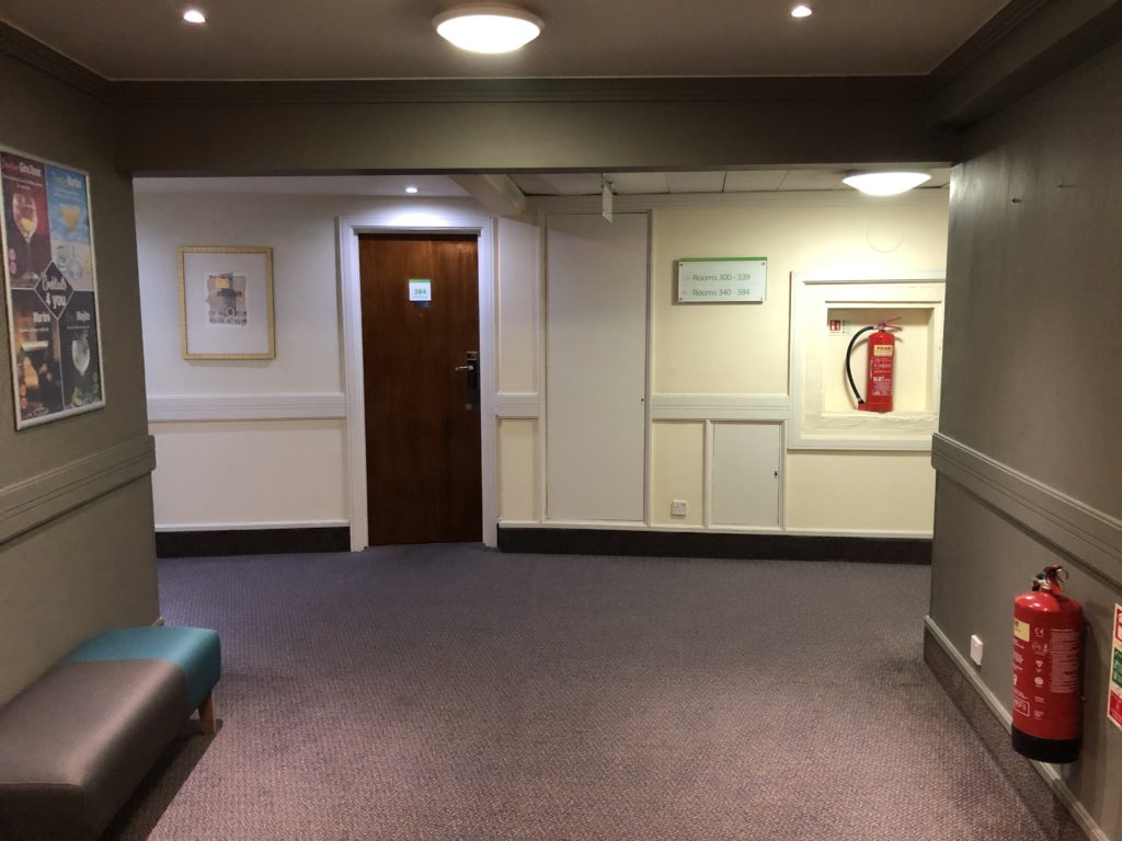 a hallway with a door and a fire extinguisher