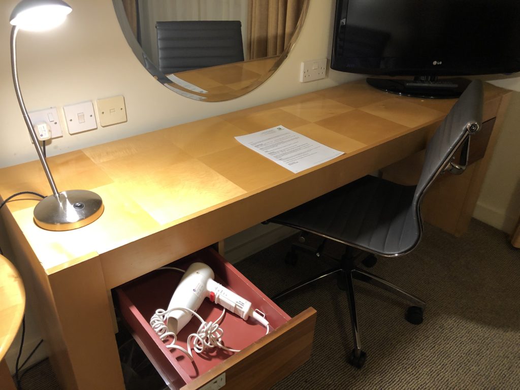 a desk with a hair dryer and a mirror