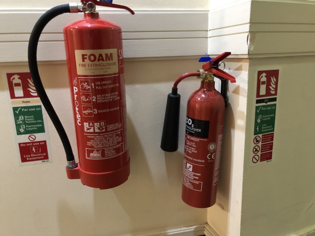 a pair of fire extinguishers on a wall