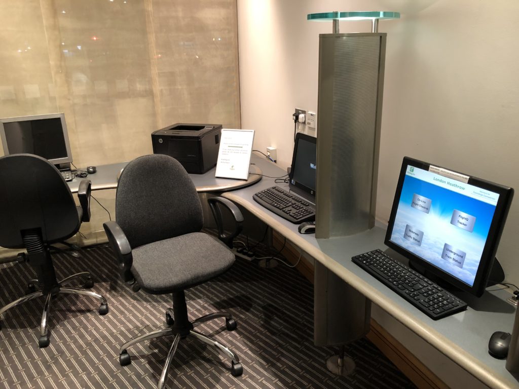 a desk with computers and a chair