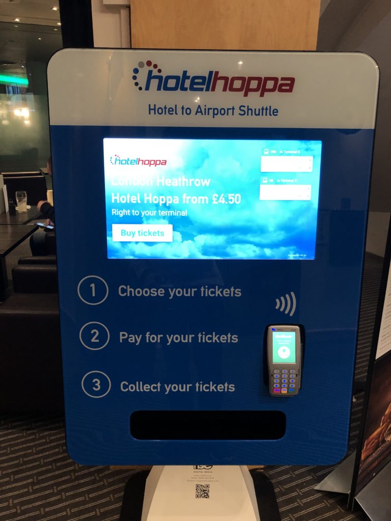 a blue ticket machine with a screen and a phone