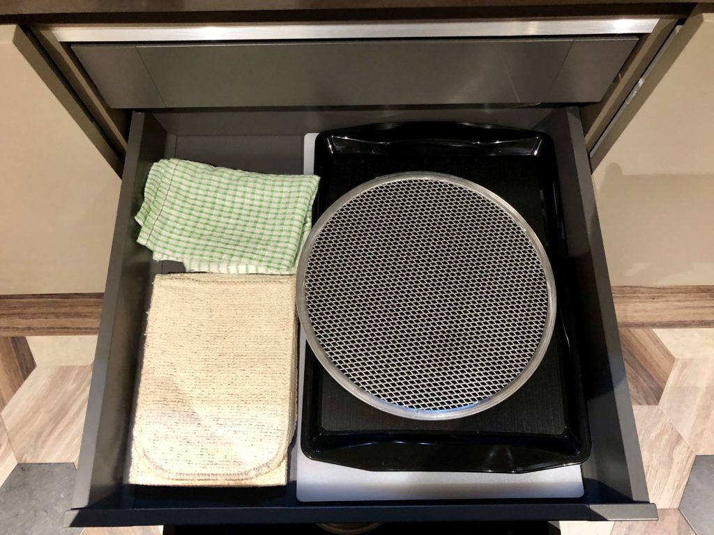 a drawer with a griddle and towels