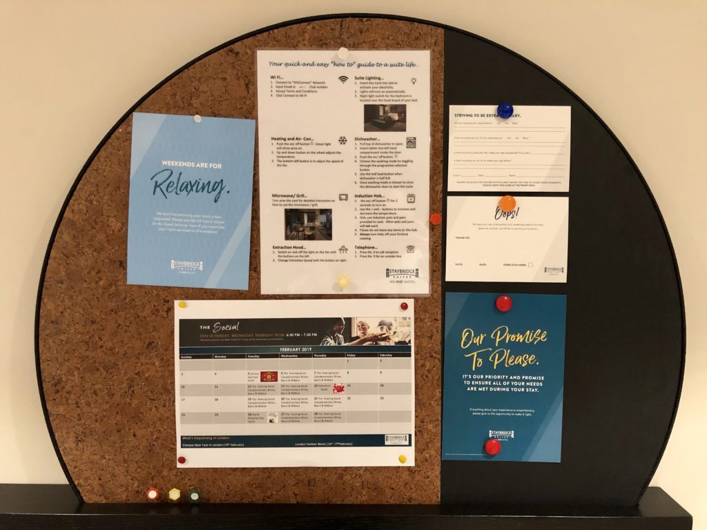 a cork board with papers pinned to it