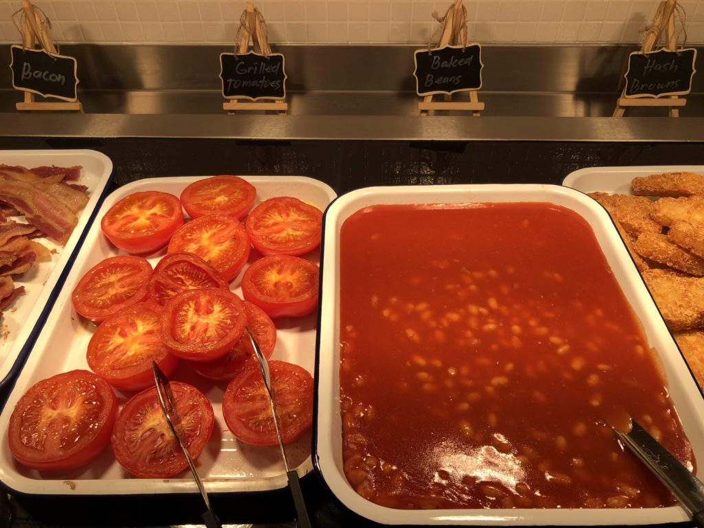 a trays of food with tomatoes and beans