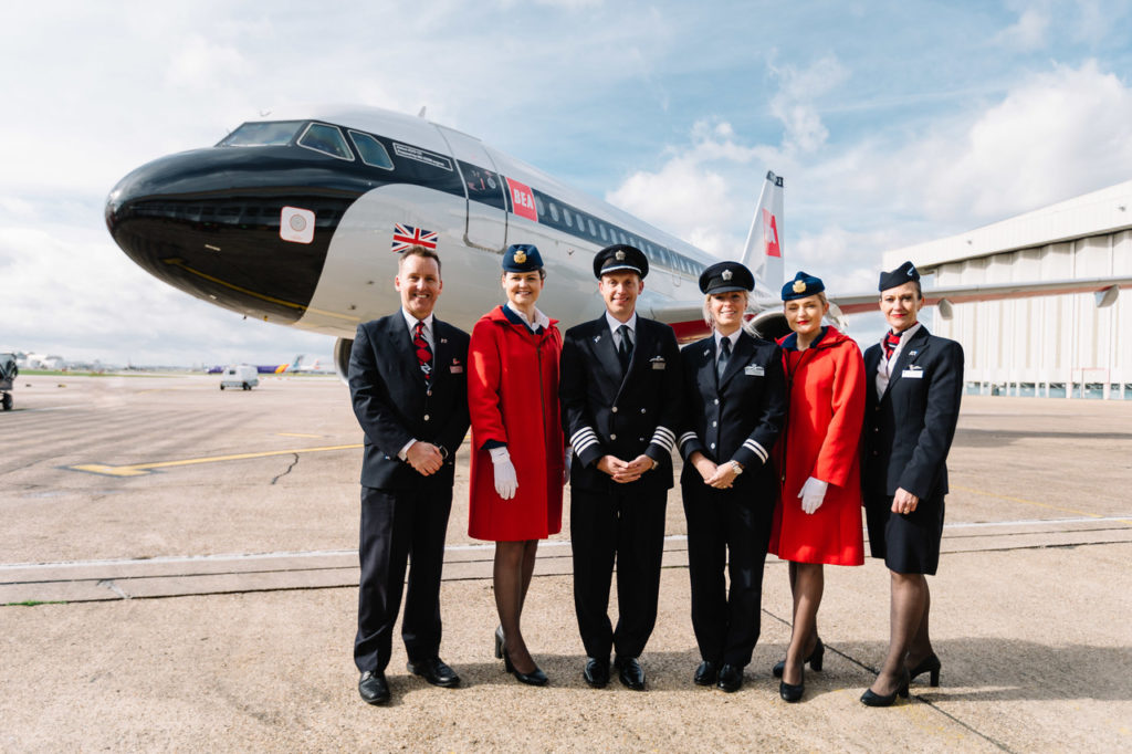 a group of people in uniform standing in front of an airplane