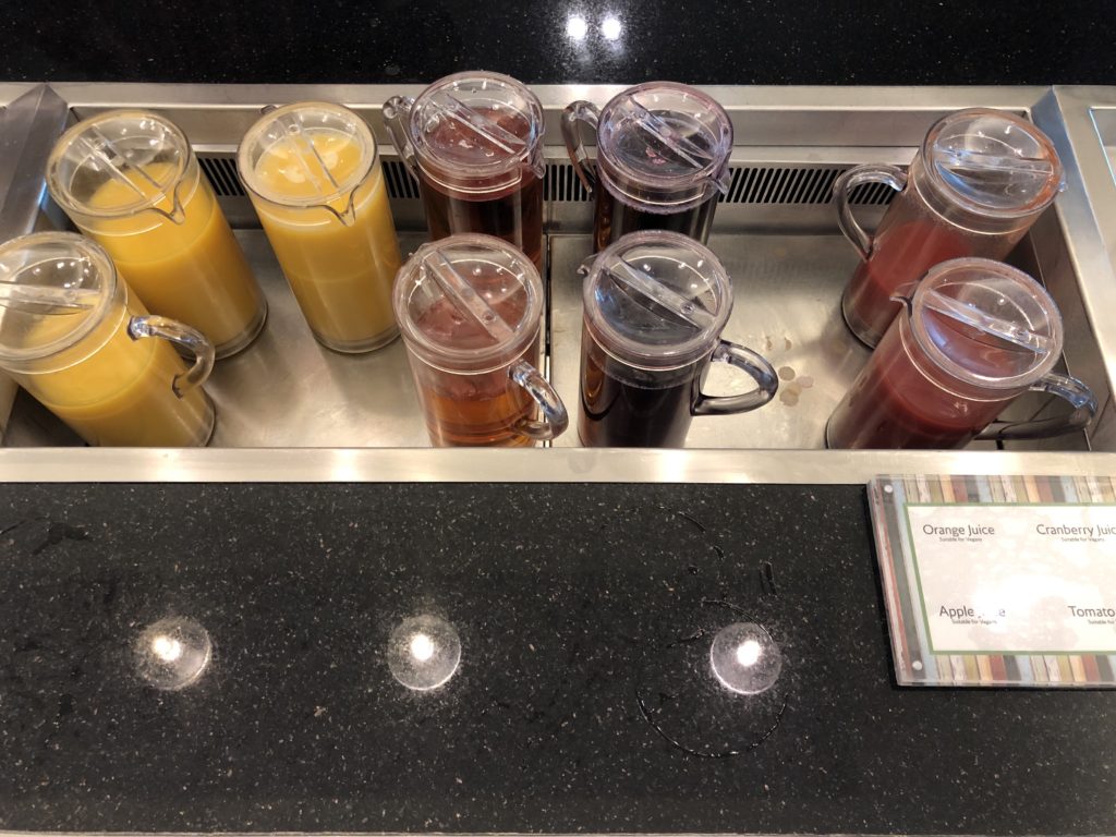 a group of juices in clear containers