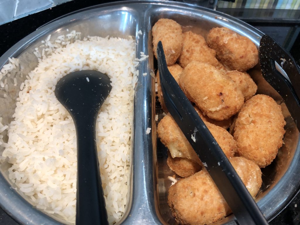 a bowl of food with a spoon and a bowl of rice