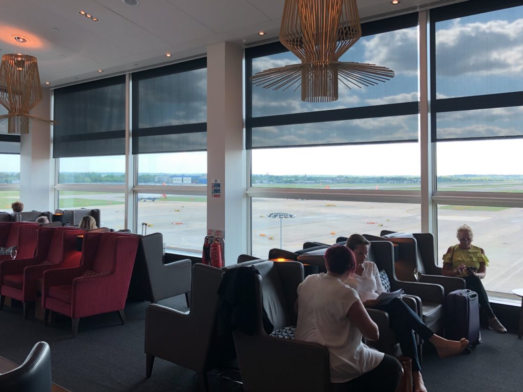 people sitting in a lounge area with large windows