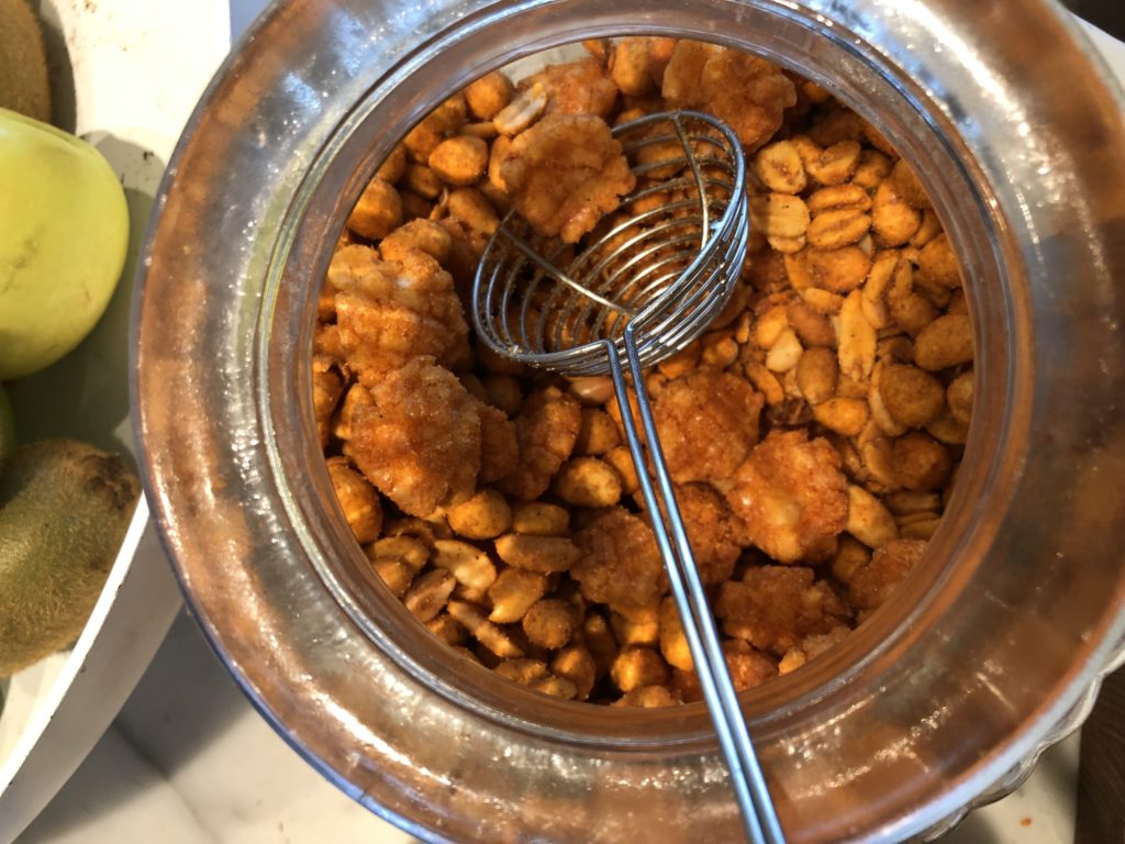 a jar of peanuts with a wire strainer